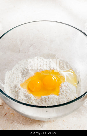 flour and eggs in mixing bowl Stock Photo