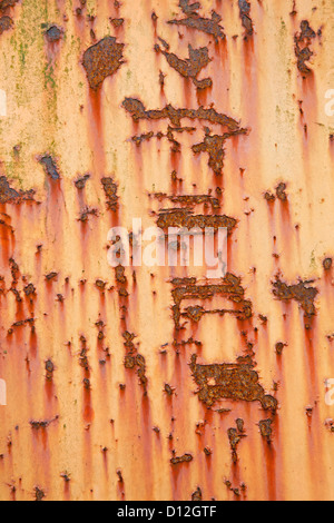 vertical part of old weathered metal with orange paint and stains Stock Photo