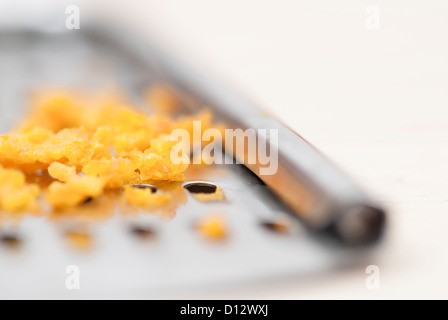 Grater and citrus zest on wooden kitchen surface. Stock Photo