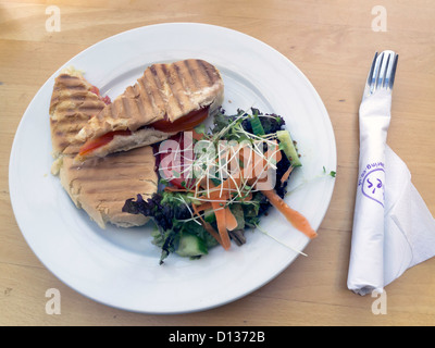 Lunch time snack, a Panini sandwich of grilled Cheddar cheese Chorizo and tomato in Ciabatta bread with salad Stock Photo