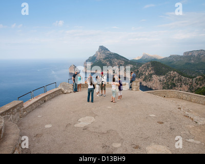 Viewpoint on Formentor peninsula Majorca , tourists at Mirador d'es Colomer with steep cliff behind Stock Photo