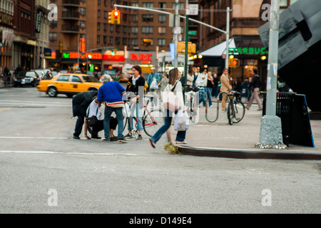 People helping some person who tripped.  Manhattan, New York City, NY, USA Stock Photo