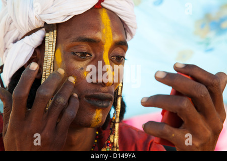 Wodaabe/ or Bororo young man is  making up in preparation for nomadic Gerewol festival
