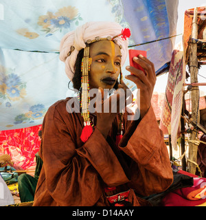 Wodaabe/ or Bororo young man is  making up in preparation for nomadic Gerewol festival