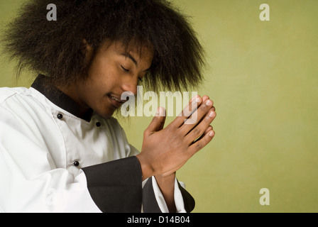 Young African American Chef Standing in Prayer Stock Photo
