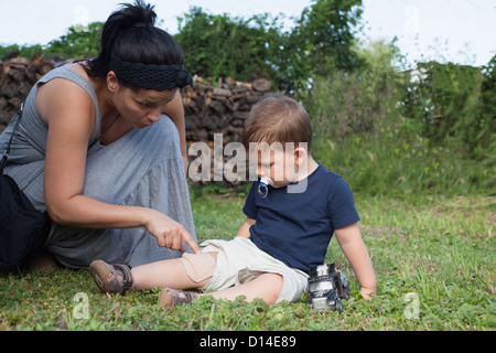 Mother putting bandage on boys knee Stock Photo