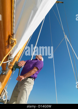 Man adjusting rigging on sailboat Stock Photo
