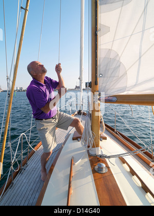 Man adjusting rigging on sailboat Stock Photo