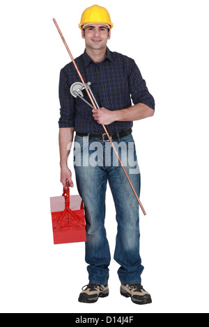 Plumber holding copper pipe and bending tool Stock Photo