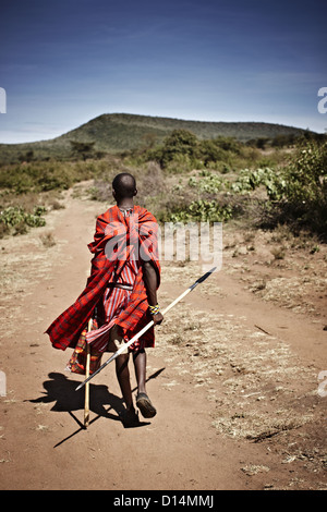 Maasai man walking on dirt road Stock Photo