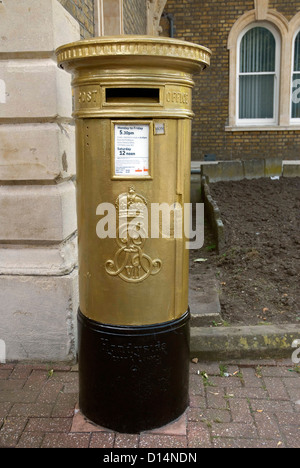 Post box painted gold outside Chiswick Town Hall to honour Pete Reed from Team GB who won the Men's Four final in the Olympics Stock Photo