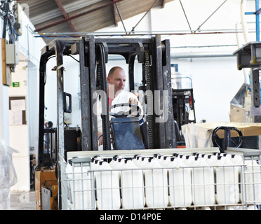 Worker driving machinery in factory Stock Photo