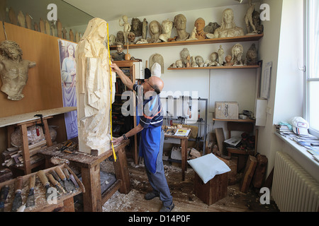 Sculptor measuring wooden figure Stock Photo