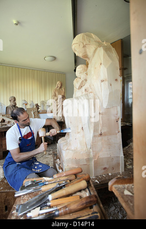 Sculptor chiseling figure from wood Stock Photo