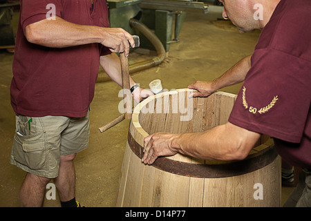Workers hammering barrel in shop Stock Photo