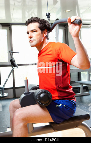 Man using exercise equipment at gym Stock Photo