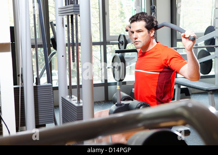 Man using exercise equipment at gym Stock Photo