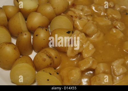 home made sweet & sour quorn chicken style pieces served with halved new potatoes sprinkled with basil Stock Photo