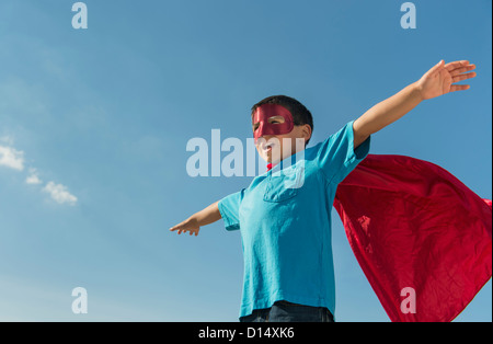 USA, New Jersey, Jersey City, Boy (6-7) in superhero costume under blue sky Stock Photo