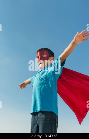 USA, New Jersey, Jersey City, Boy (6-7) in superhero costume under blue sky Stock Photo