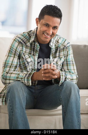 USA, New Jersey, Jersey City, Man sitting on sofa Stock Photo