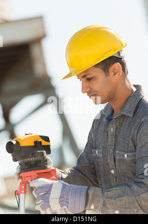 USA, New Jersey, Jersey City, Construction worker adjusting theodolite Stock Photo