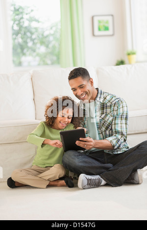 USA, New Jersey, Jersey City, Father using digital tablet with daughter (6-7) Stock Photo