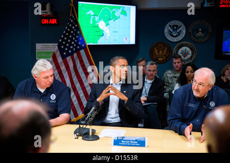 US President Barack Obama receives an update on the ongoing response to Hurricane Sandy at the National Response Coordination Center at FEMA headquarters October 28, 2012 in Washington, DC. Seated with the President are FEMA Deputy Administrator Richard Serino, left, and FEMA Administrator Craig Fugate. Stock Photo