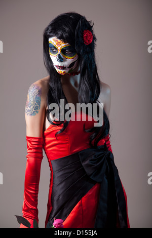 Sugar skull girl in red evening dress, studio shot Stock Photo