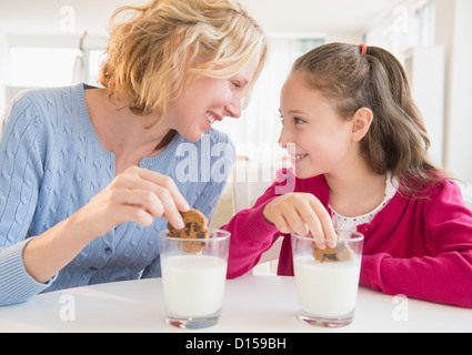 USA, New Jersey, Jersey City, Mother and daughter (8-9 years) eating cookies with milk Stock Photo
