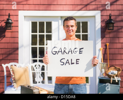 USA, New Jersey, Mendham, Portrait of man holding garage sale sign Stock Photo