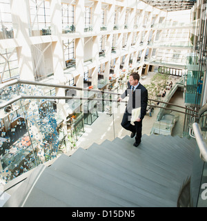 USA, Utah, Salt Lake City, Man walking up stairs in office Stock Photo