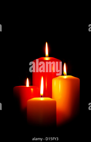 Four red and white Christmas candles on a black background. Stock Photo