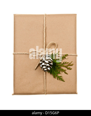 Christmas gift in brown wrapping and string with pine cone decoration isolated on white Stock Photo