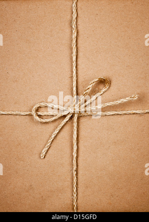 Gift package wrapped in brown paper tied with twine closeup Stock Photo