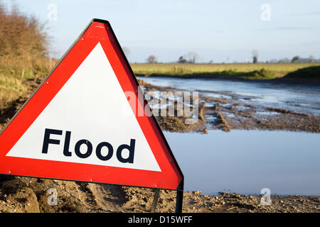 A Flood warning sign next to the road with flood waters just behind it. Norfolk,UK. Stock Photo