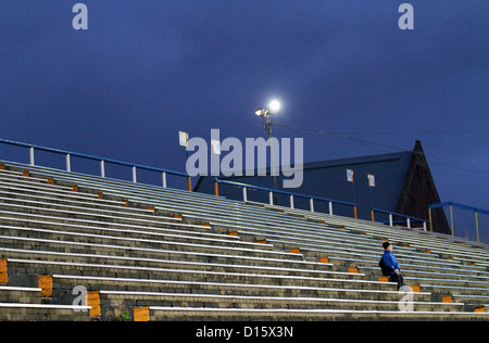 Ballboy at Greenock Morton football match sitting in empty stands. Scotland. Stock Photo