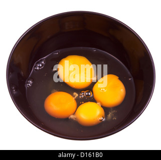 four chicken broken egg in black ceramic bowl isolated on white background Stock Photo