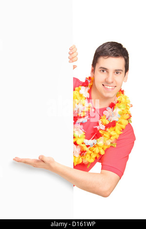A portrait of a smiling man wearing hawaian costume and gesturing on a blank panel isolated on white background Stock Photo