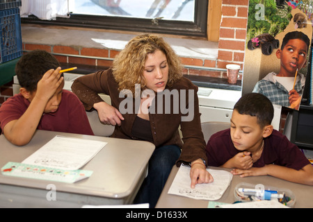 Teacher helps two of her students Stock Photo