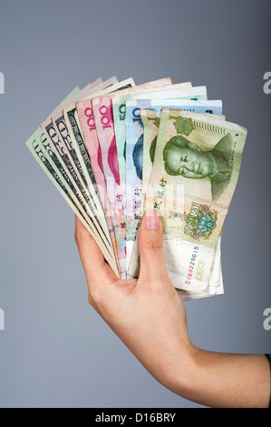 Young woman's hands holding American dollars and Chinese Yuan banknotes Stock Photo