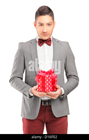 A handsome guy with bow tie holding a gift isolated on white background Stock Photo