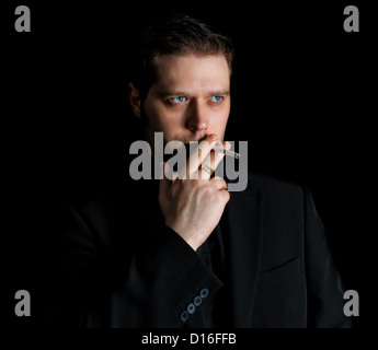 Portrait of smoking man in black suit Stock Photo