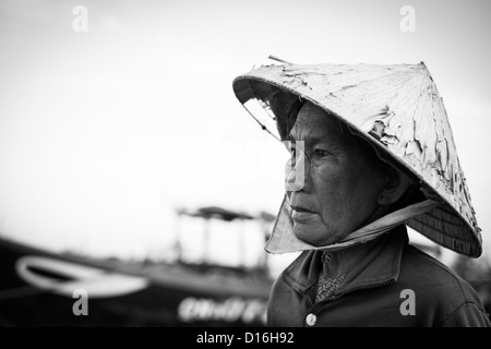 Black and White Image of a Vietnamese Female wearing a tatty bamboo hat Stock Photo