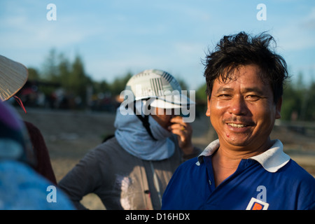 Smiling Vietnamese male in warm sunlight wearing a blue polo short with white collar Stock Photo