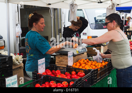 Woman pays for items bought at an open-air stand at the Farmers' Market in 'Santa Barbara', California Stock Photo