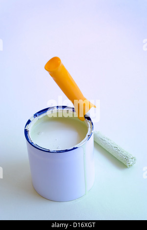 Home improvement painting roller resting on paint tin container. Stock Photo