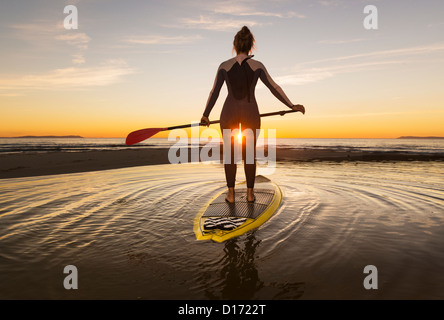 Woman at sunset on her stand up paddle surf board. Tarifa, Costa de la Luz, Cadiz, Andalusia, Spain.