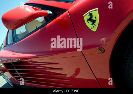 A Ferrari badge on the side of a red Ferrari supercar. Stock Photo