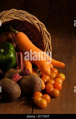 Thanksgiving cornucopia filled with autumn fruits and vegetables on wooden table. Stock Photo
